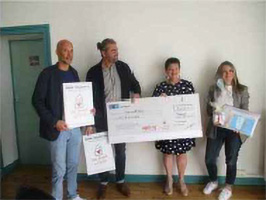 Personnes tenant un chèque Raval Façades 64.